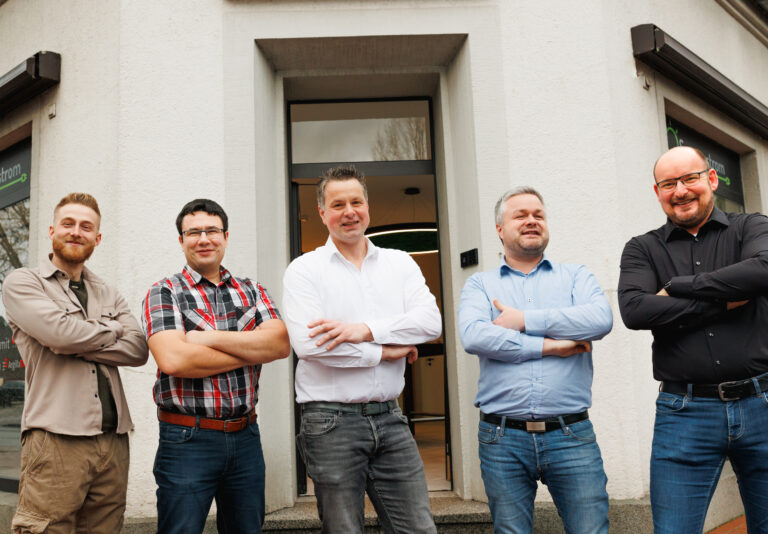 Fünf Mitarbeiter des Sonnenstrom-Teams stehen lächelnd vor dem Firmengebäude in Raesfeld