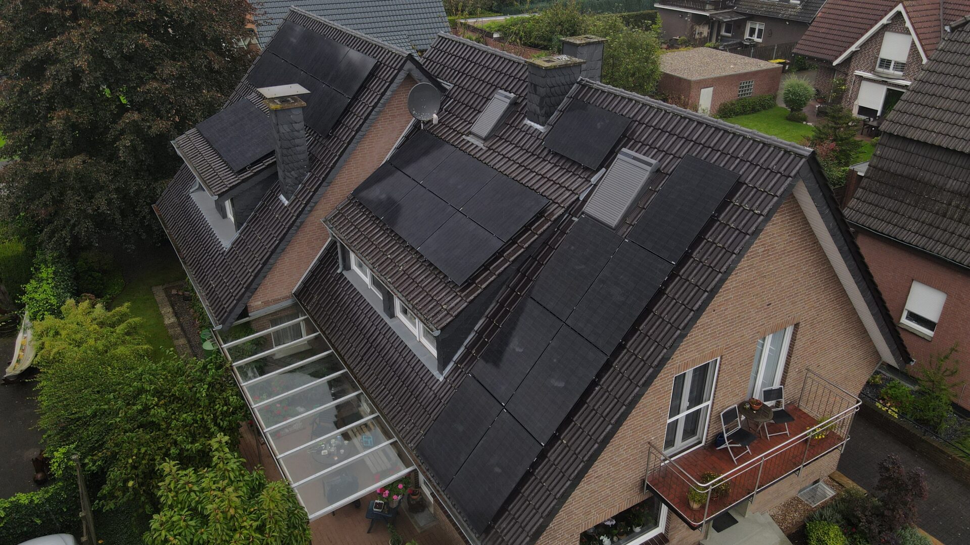 Schrägaufnahme eines Wohnhauses mit mehreren Solarmodulen auf einem geneigten Dach.