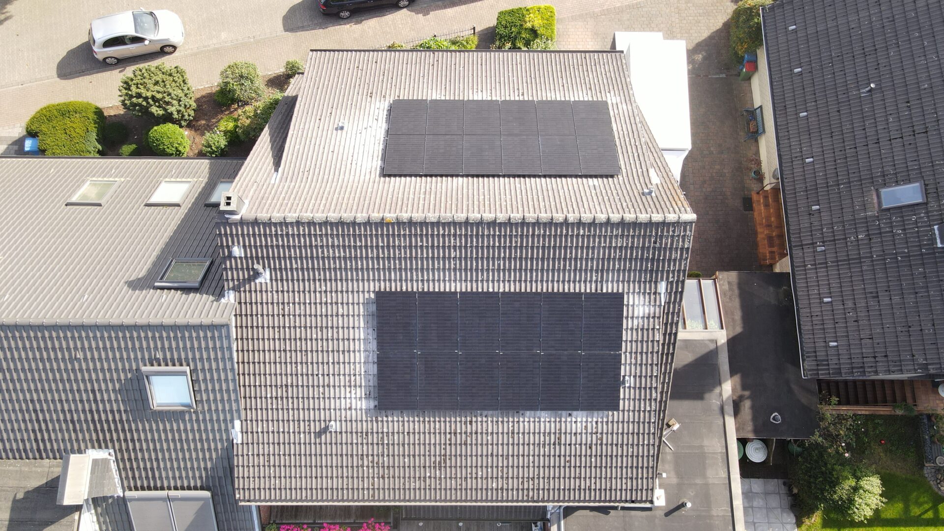 Drohnenansicht eines Hauses mit Solar­panelen auf einem Dachbereich.