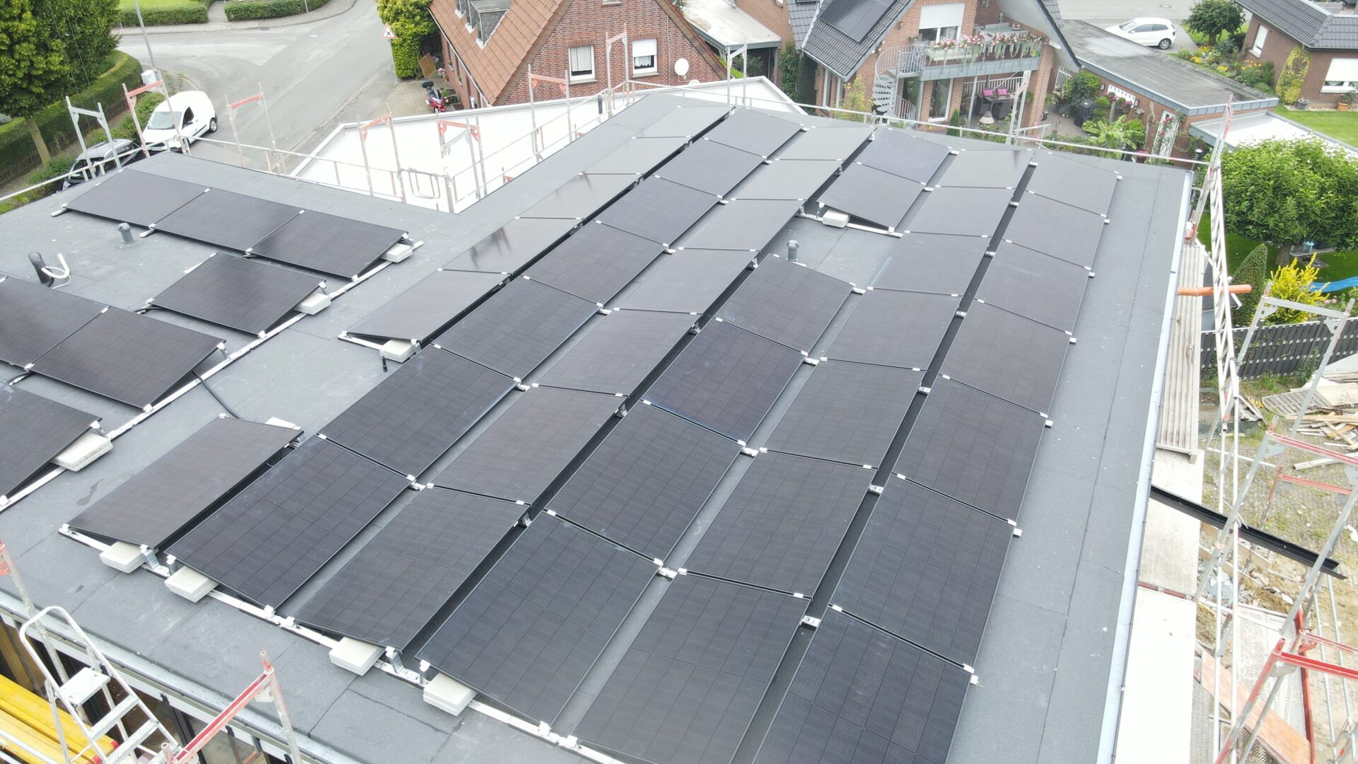Luftaufnahme einer rechteckigen Solar­anlage auf einem Wohnhausdach.